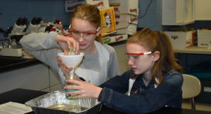two girls in science lab working on a project