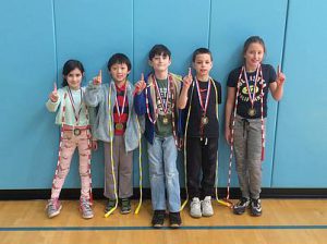 five students with jump ropes and medals over their shoulders