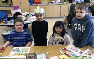 four students making 100th day of school hats
