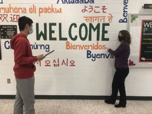 student and teacher in front of mural