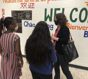 teacher with students discussing mural