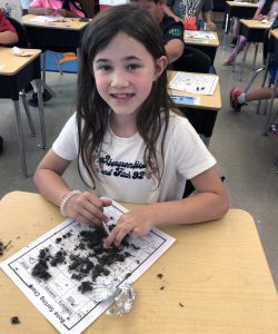 student with owl pellets