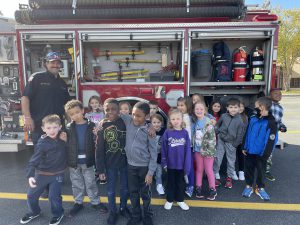 students standing in front of fire truck