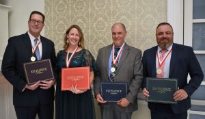Four people with awards
