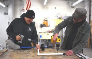 Men building a hockey stick in the shop.