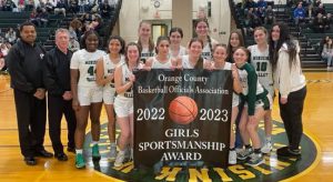 girls basketball team with banner