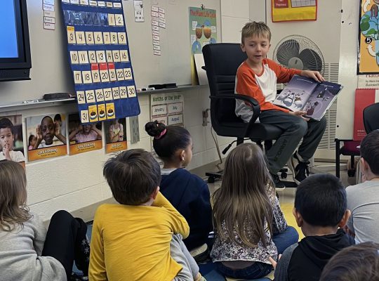 student reading to little children